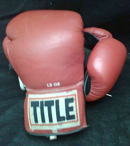 TITLE BOXING GLOVES 12oz VERY WELL USED. (THE RIGHT HAND GLOVE IS VERY WORN)