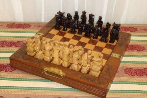 A SUPERB VINTAGE HAND-CARVED ORIENTAL FOLDING CHESS BOARD AND CARVED CHESS SET IN AWESOME CONDITION