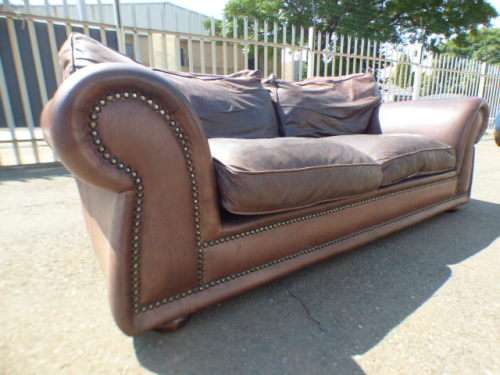 A stunning x-large modern styled brown genuine leather couch in great condition.