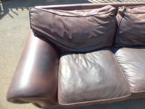 A stunning x-large modern styled brown genuine leather couch in great condition.