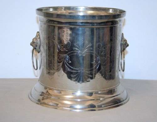 A stunning silver plated wine cooler with beautiful engraved detailing and lion-head ring handles