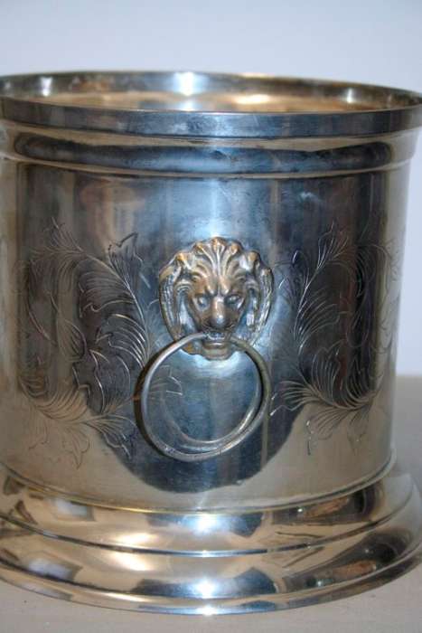 A stunning silver plated wine cooler with beautiful engraved detailing and lion-head ring handles