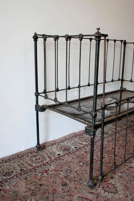 A stunning & rare antique (late 1800's) wrought iron baby's cot w/ dropside on its original castors