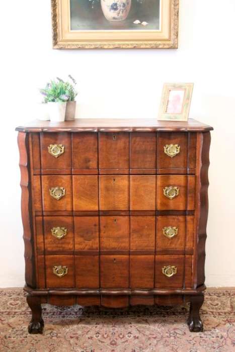 An exquisite vintage Imbuia 4-drawer chest of drawers with ornate handles and ample storage space