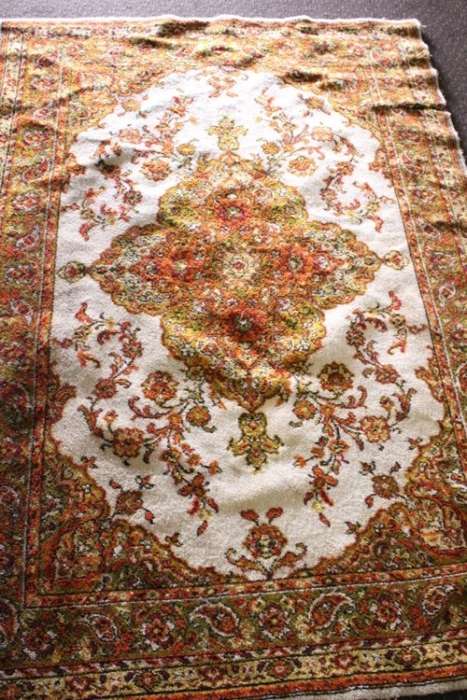 A vintage 189cm x 132cm Persian styled carpet w/ dark greens, marigold yellow, rust & earthy colours