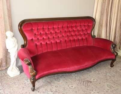 A gorgeous antique Victorian 3 seater settee couch w carved detailing and period style upholstery.
