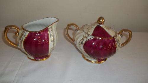 AN AWESONME DEEP PINK PORCELAIN MILK JUG AND SUGAR BOWL WITH STUNNING GOLD DESIGN WORK