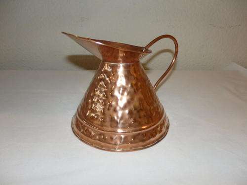AN EXQUISITE HAND HAMMERED COPPER CARAFE/ JUG WITH A THIN HANDLE AND BROAD SPOUT