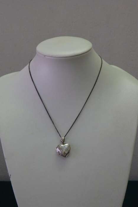 A BEAUTIFUL ENGRAVED/ DETAILED STERLING SILVER HEART-SHAPED LOCKET ON A SILVER CHAIN