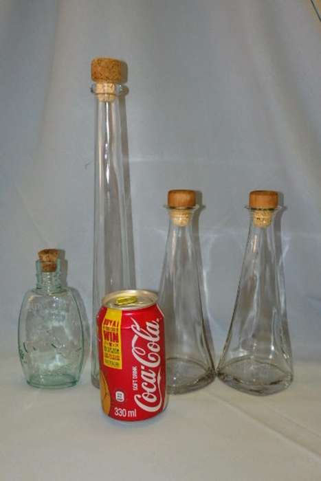 AN AWESOME COLLECTION OF FOUR ASSORTED CLEAR GLASS BOTTLES WITH CORK STOPPERS bid/bottle