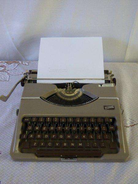 AN AMAZING ANTIQUE(1955) GOSSEN TIPPA, TYPEWELL PORTABLE TYPEWRITER IN ITS ORIGINAL HARD CARRY CASE.