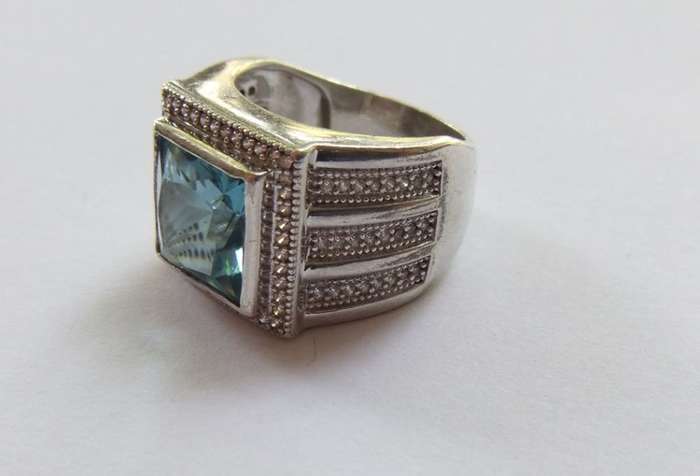 A SUPERIOR QUALITY SOLID STERLING SILVER RING SET WITH A BEAUTIFULLY FACETED BLUE STONE AND MORE !!