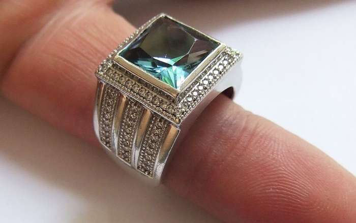 A SUPERIOR QUALITY SOLID STERLING SILVER RING SET WITH A BEAUTIFULLY FACETED BLUE STONE AND MORE !!