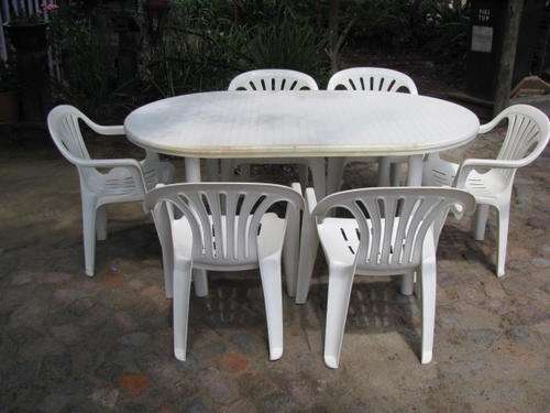 A PLASTIC PATIO TABLE AND 6 CHAIRS IN GOOD CONDITION