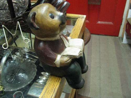 A CUTE SEATED WOODEN PAINTED TEDDY READING
