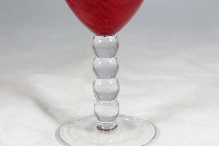 Large red glass on a bubbled stem