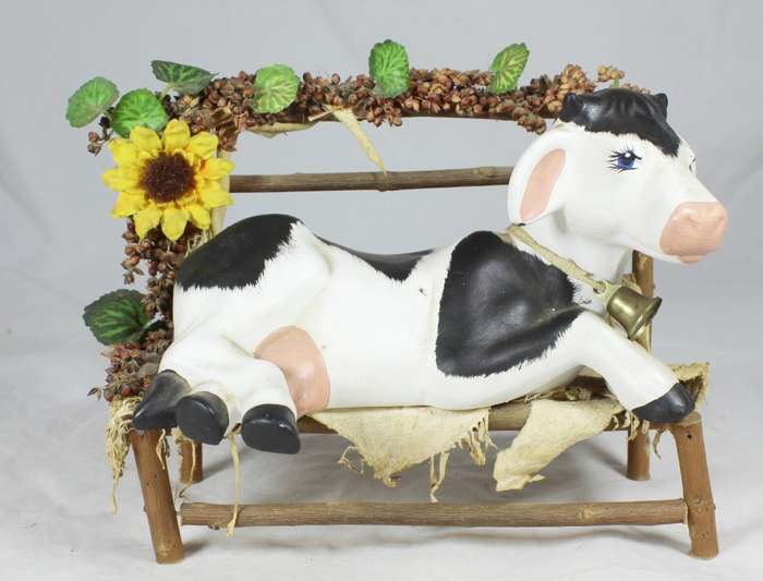 Cow laying on a wooden bench