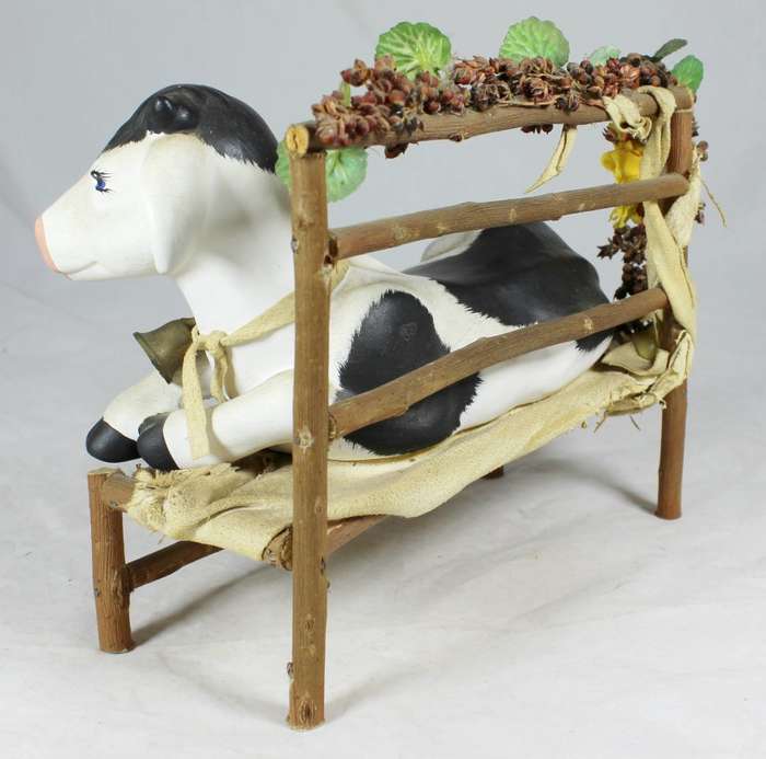 Cow laying on a wooden bench
