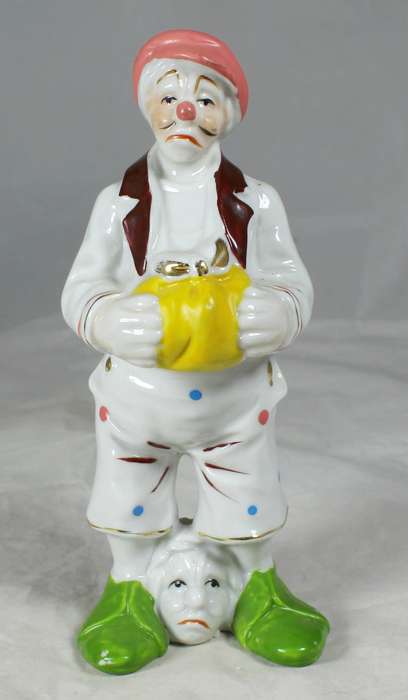 Clown with a head between feet