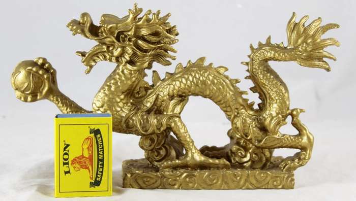 Golden dragon holding crystal ball