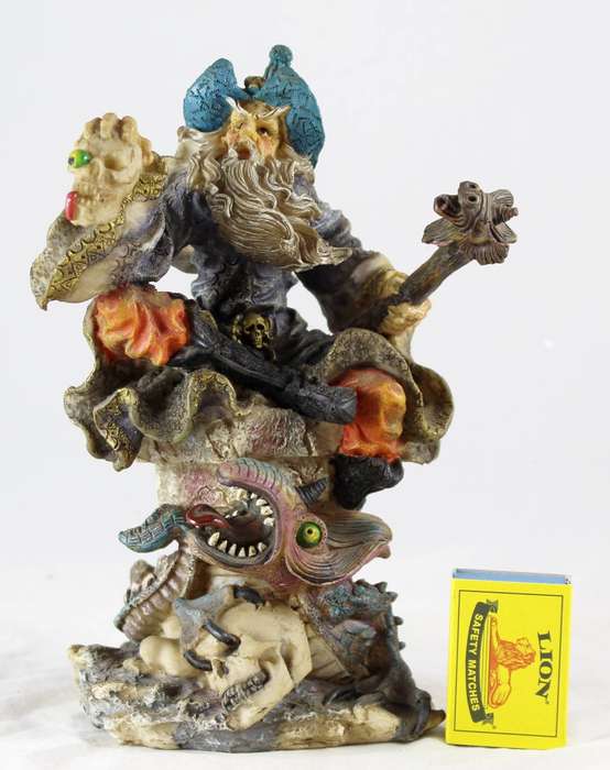 Large wizard seated with skull & unicorn head staff