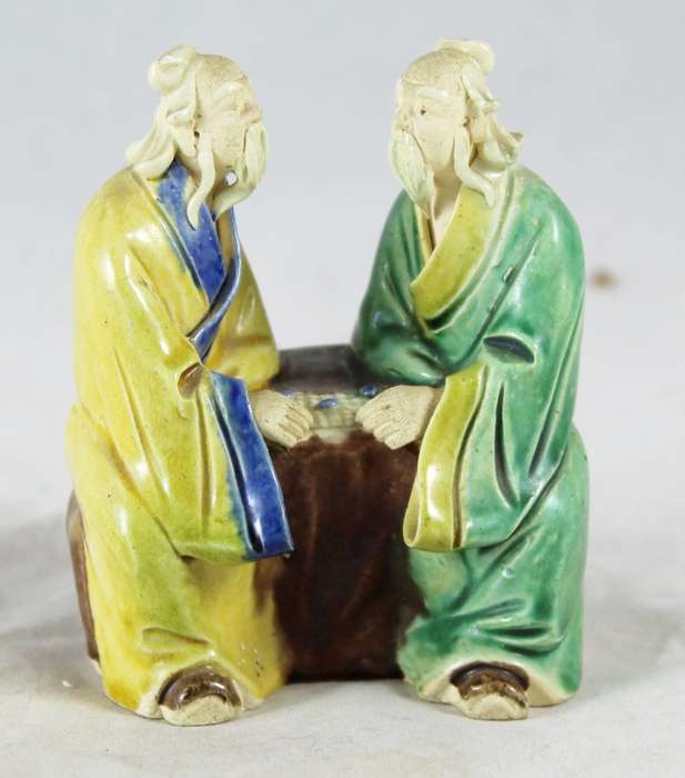 Mud men playing a board game