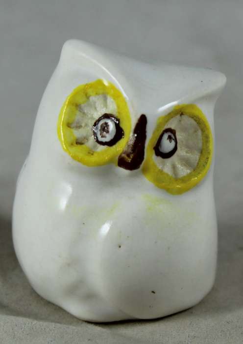 Miniature porcelain owl with large yellow eyes