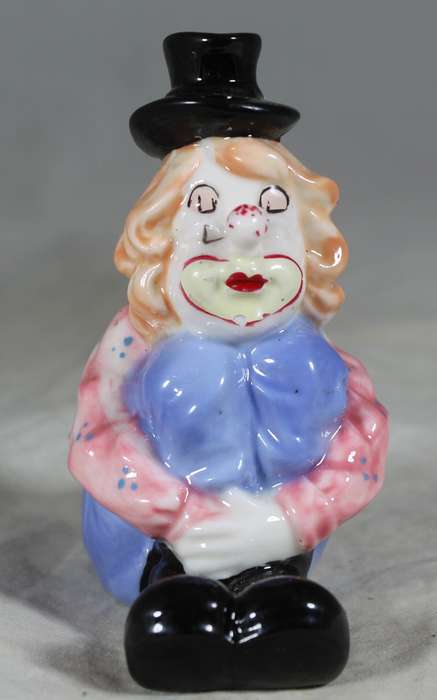 Seated clown with pulled up legs