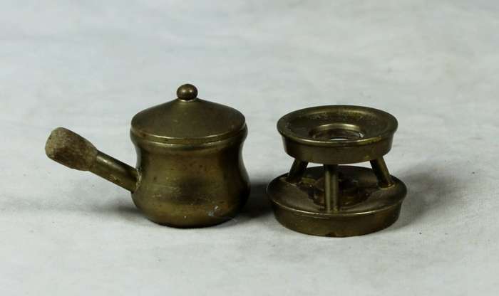 Miniature brass pot on a gas stove