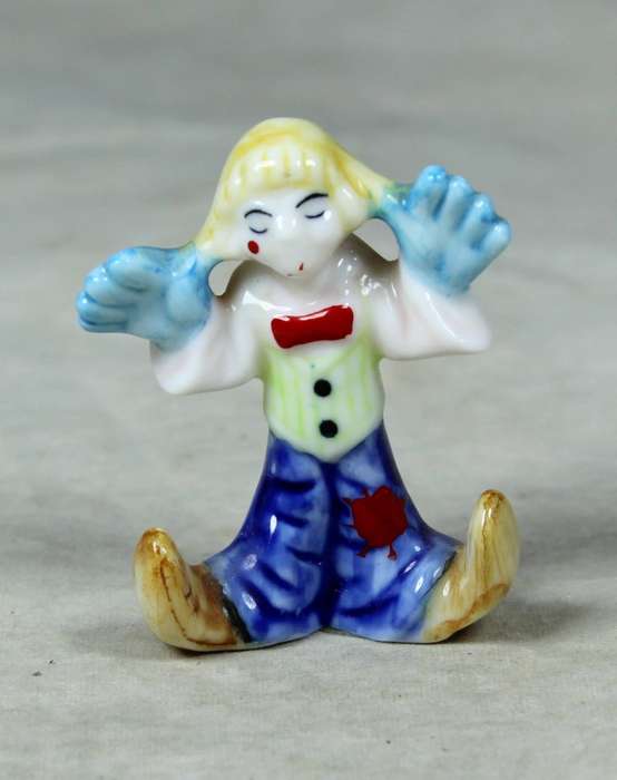 Miniature clown with his hands on his ears