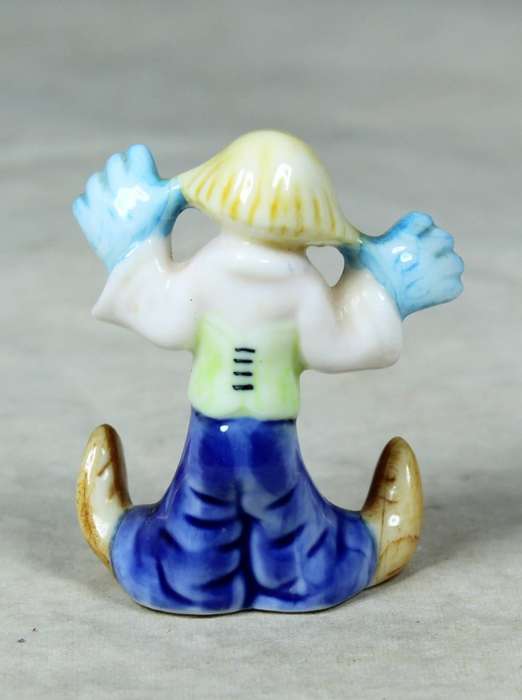 Miniature clown with his hands on his ears
