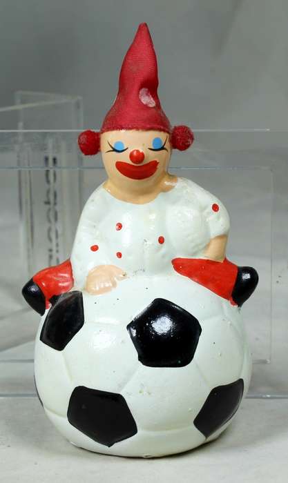 Small clown in a polka dot suit and hat  on a large ball