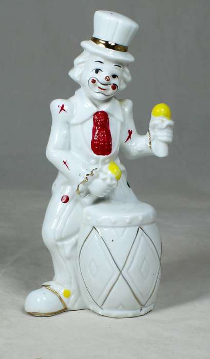 Clown in a polka dot suit playing a drum