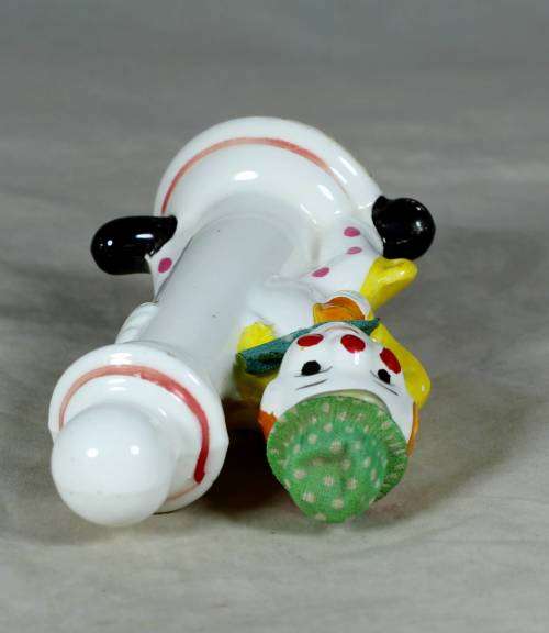 Porcelain clown in a green hat holding a lamppost