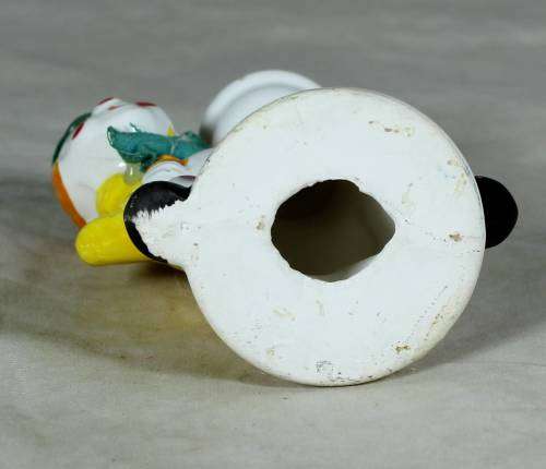 Porcelain clown in a green hat holding a lamppost
