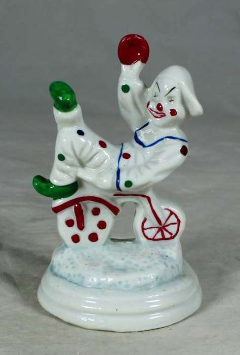 Porcelain clown sitting on a tricycle
