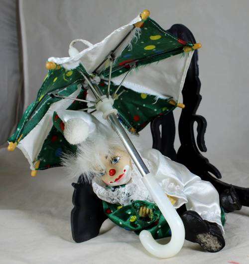 Clown lying down with an umbrella