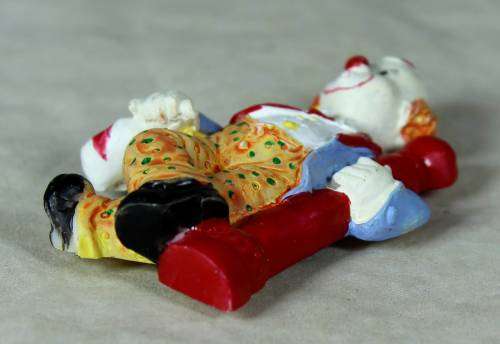 Molded clown fridge magnet holding onto a lamp post