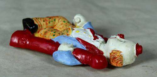 Molded clown fridge magnet holding onto a lamp post