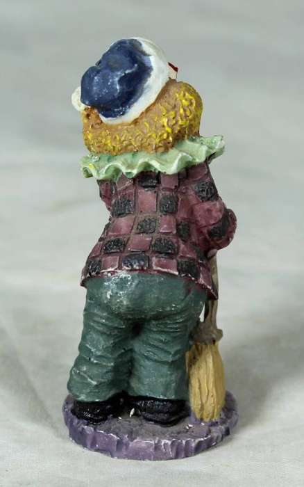 Molded clown on a stand holding a broom