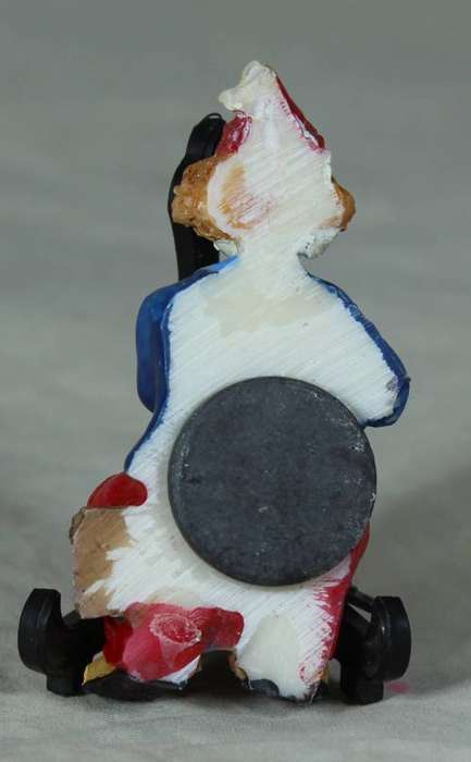 Molded clown fridge magnet sitting on a log