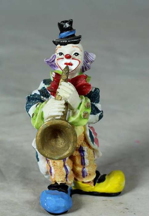 Molded clown playing a trumpet