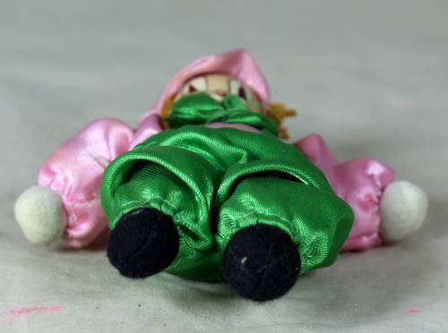 porcelain and cloth clown dressed in green and pink