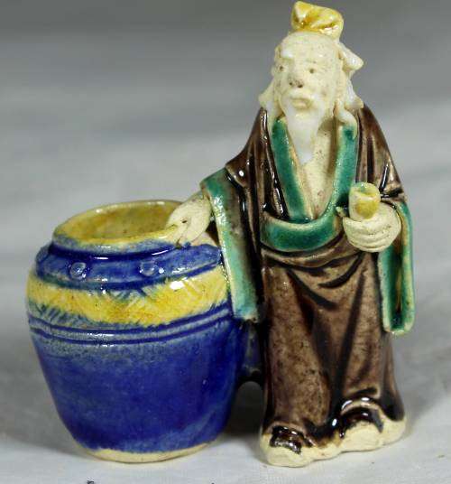 Mud men - old man holding onto a large barrel