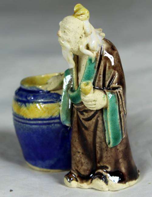 Mud men - old man holding onto a large barrel