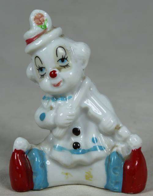 Miniature clown seated, playing a violin