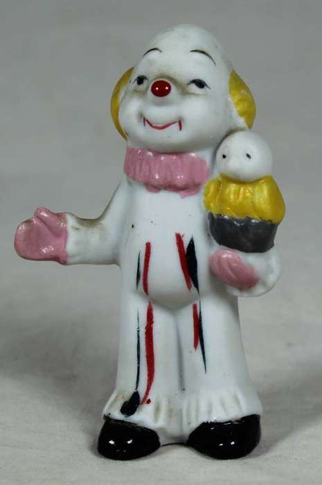 Miniature clown holding a bird