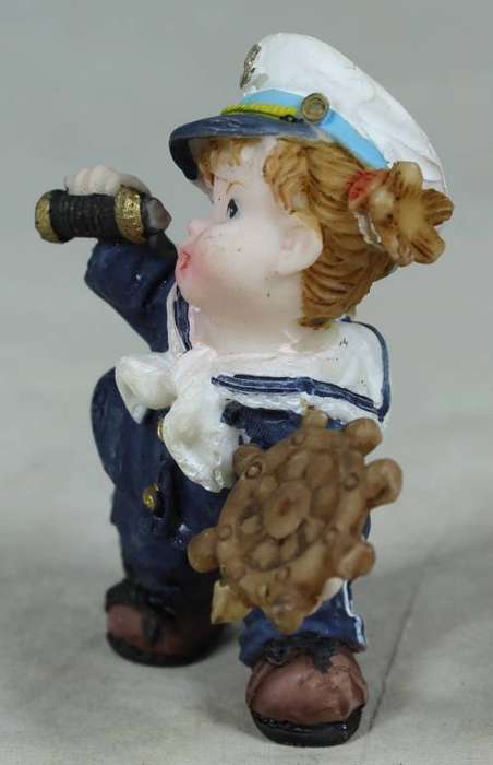 Kid sailor in blue holding a telescope and ships wheel