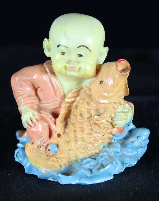Little monk sitting with fish