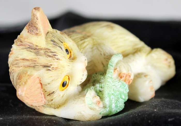 Small cat playing with ball of yarn